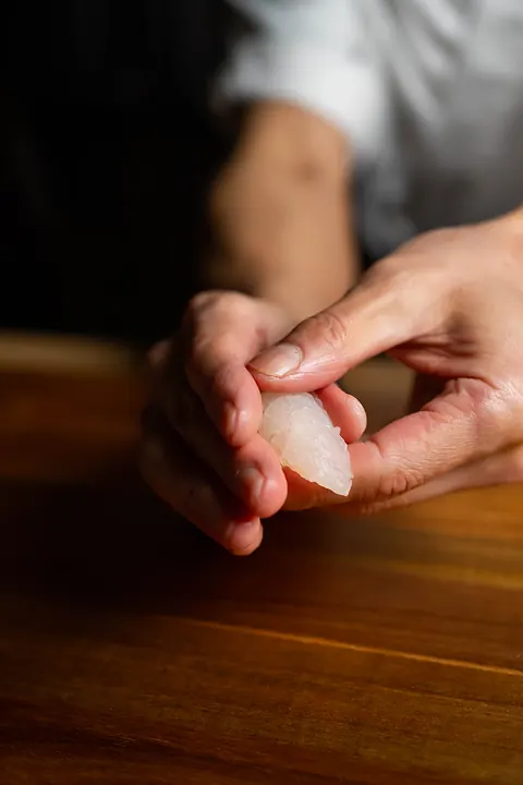 A chef forming nigiri by hand