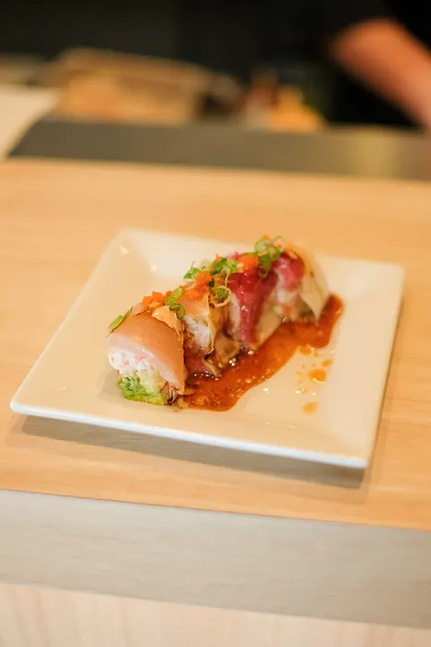A sliced roll with sauce on a white plate
