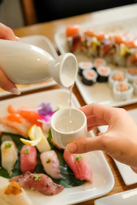 Sake poured over a table of sushi