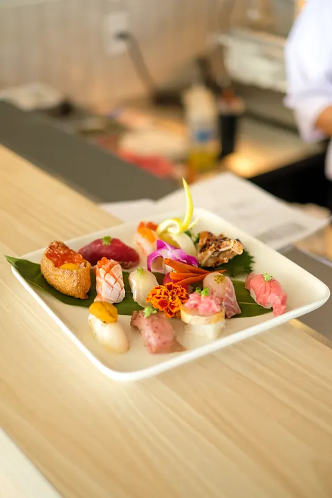A plate of nigiri set down at the sushi bar