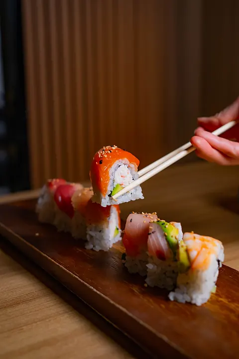 A roll on a wooden board with chopsticks
