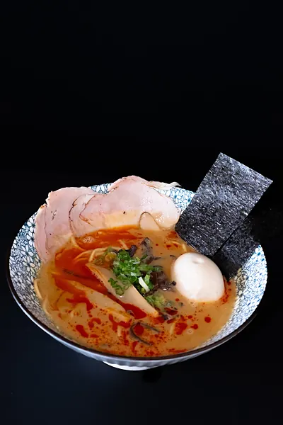 A bowl of ramen in a red broth