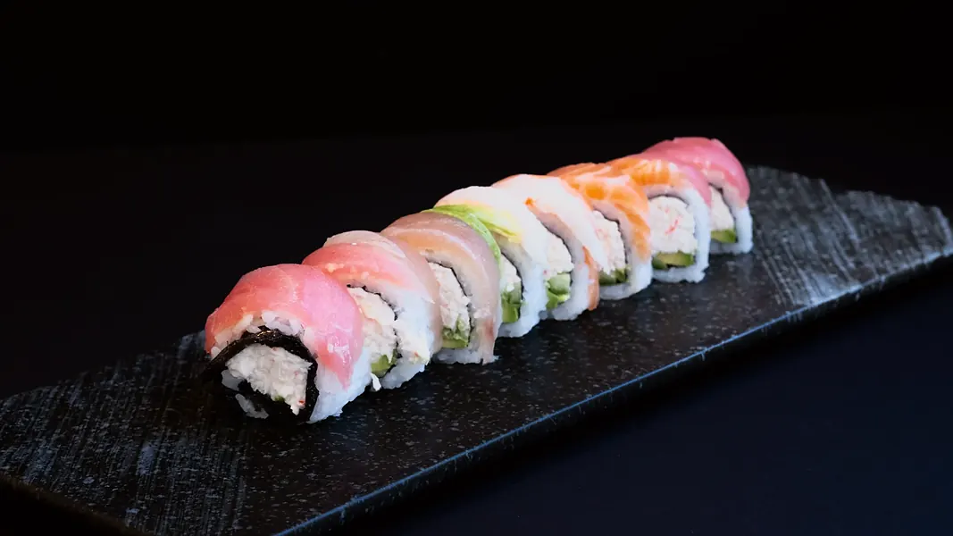 A roll topped with different fish on slate