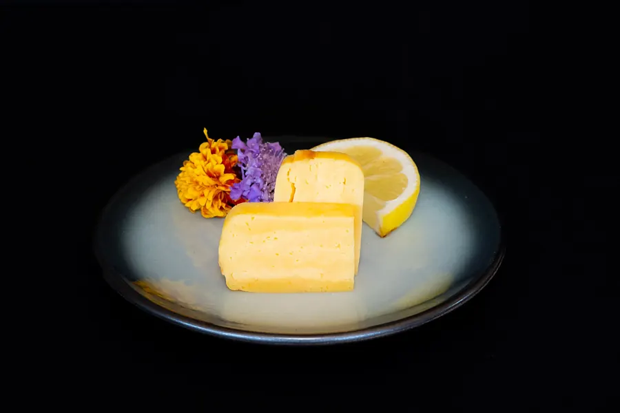 Egg nigiri with a lemon wedge