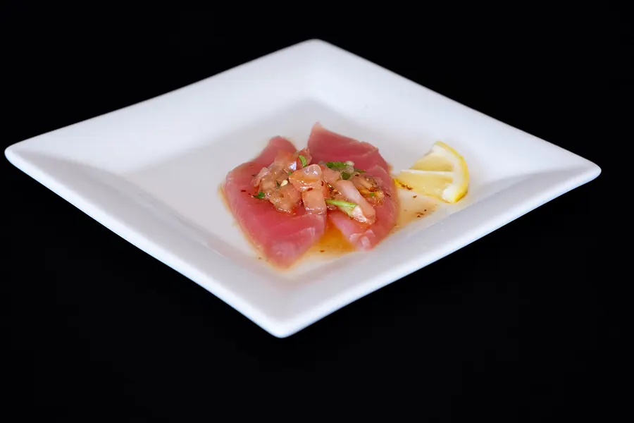 Seared tuna slices on a square plate