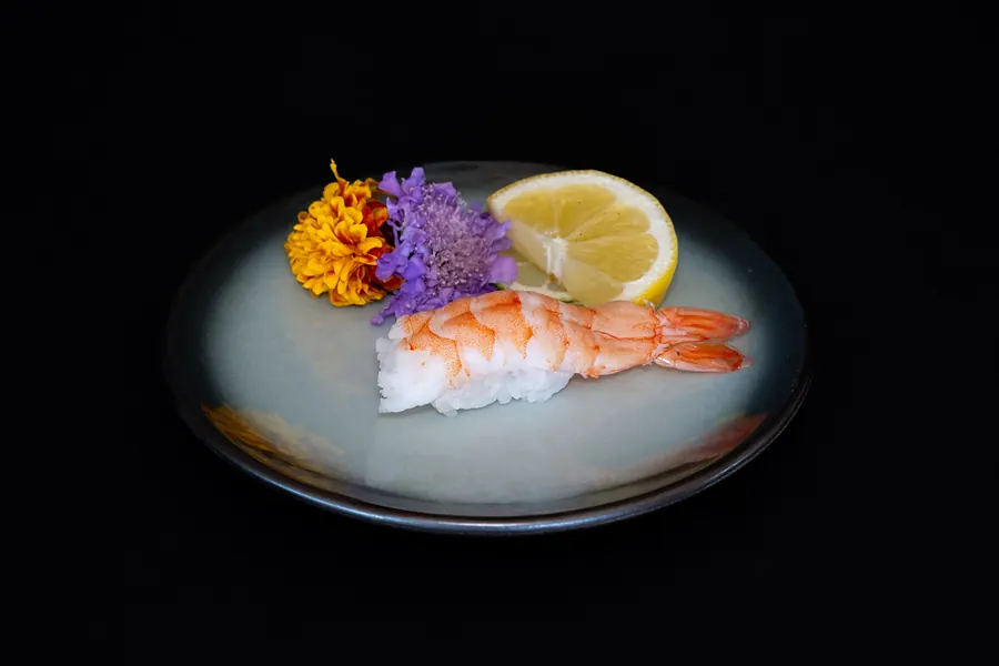 Shrimp nigiri with a lemon wedge