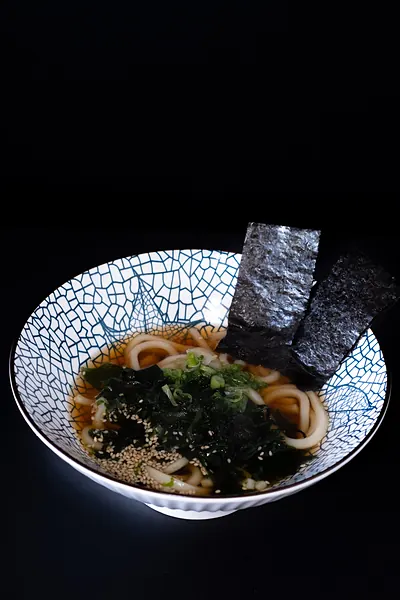 A bowl of udon with seaweed