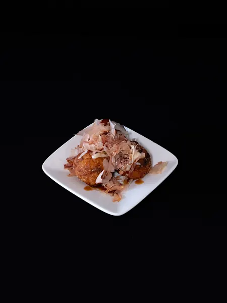 A small plate topped with bonito flakes
