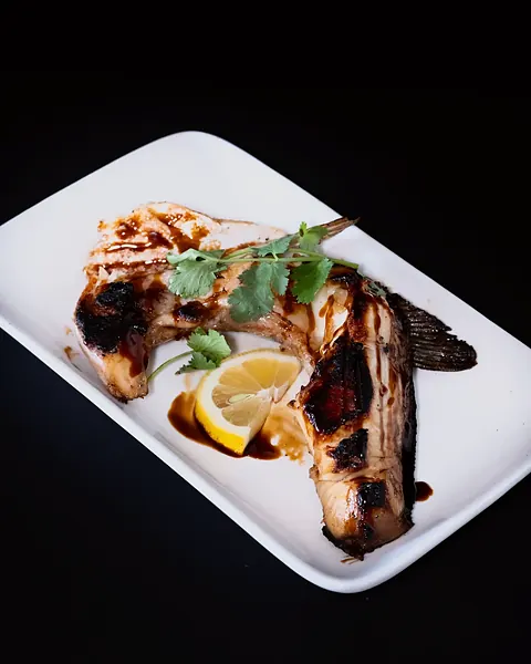 A grilled cut of fish with lemon
